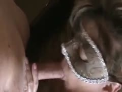 A chubby woman wearing a mask swallows her new lover's enormous pecker.